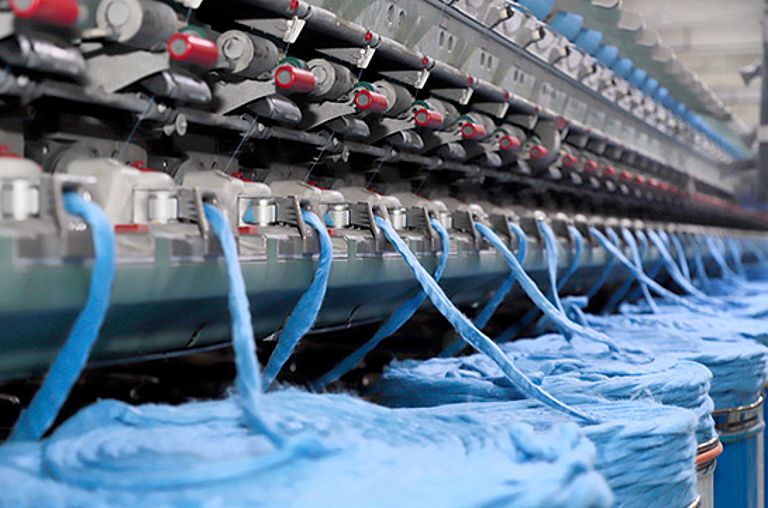 Rotor spinning machine R 37 spins fibers from used garments and waste into yarn.